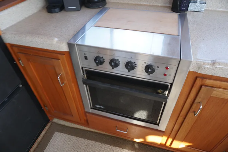 Slide: The Image of Stainless steel oven in 2004 American Tug 34 boat kitchen, surrounded by wooden cabinetry. - 10