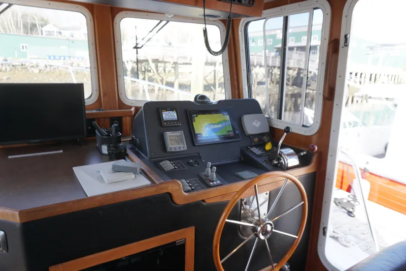 Slide: The Image of Pilot house of a 2004 American Tug 34 with navigation equipment and steering wheel. - 13