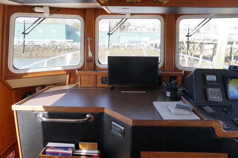 Slide: The Image of Pilothouse interior of 2004 American Tug 34, featuring navigation equipment and large windows. - 14
