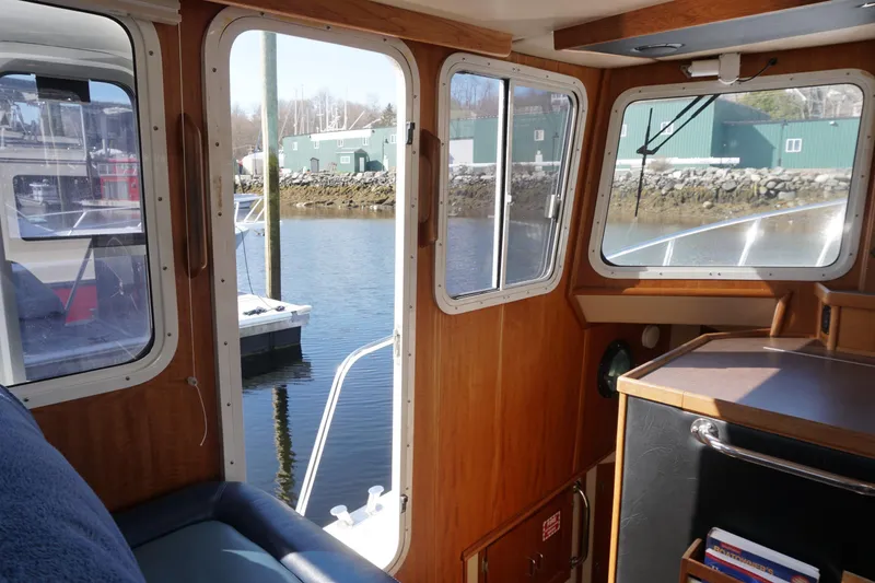 Slide: The Image of Interior view of a 2004 American Tug 34, showcasing windows and wooden paneling. - 15