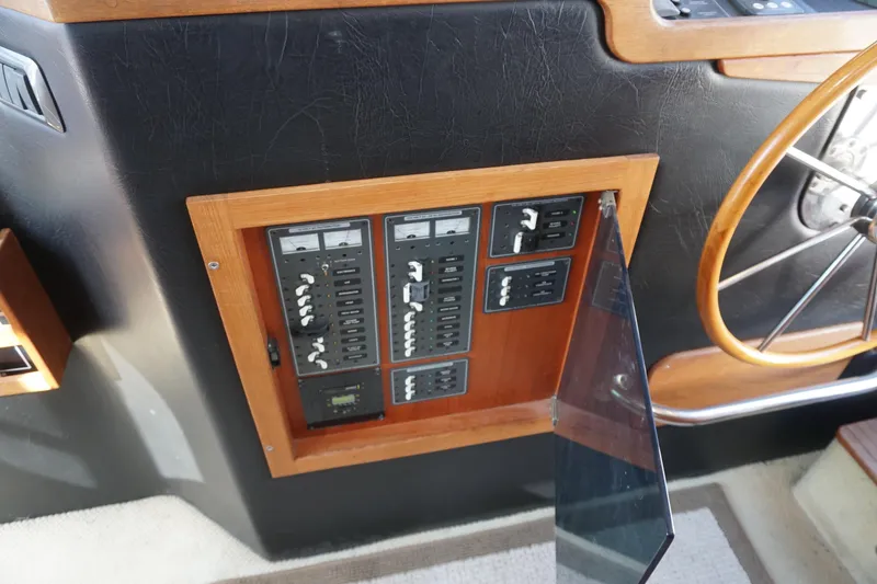 Slide: The Image of Electrical panel on a 2004 American Tug 34 boat, featuring switches and a wooden frame. - 16