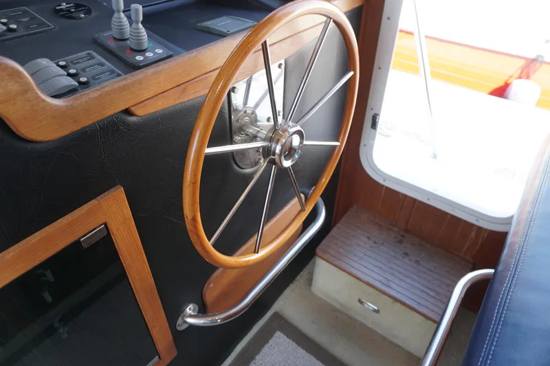 Slide: The Image of Steering wheel of a 2004 American Tug 34 boat, featuring wooden and metal accents. - 17