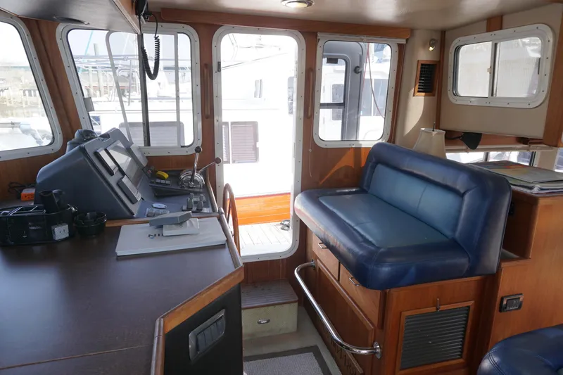 Slide: The Image of Interior of a 2004 American Tug 34, featuring helm and seating area. - 19