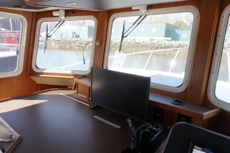 Slide: The Image of Interior view of 2004 American Tug 34, featuring large windows and a control panel. - 21
