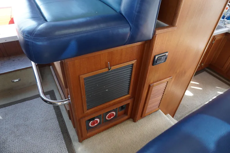 Slide: The Image of Interior of a 2004 American Tug 34, featuring blue seating and wooden cabinetry. - 25