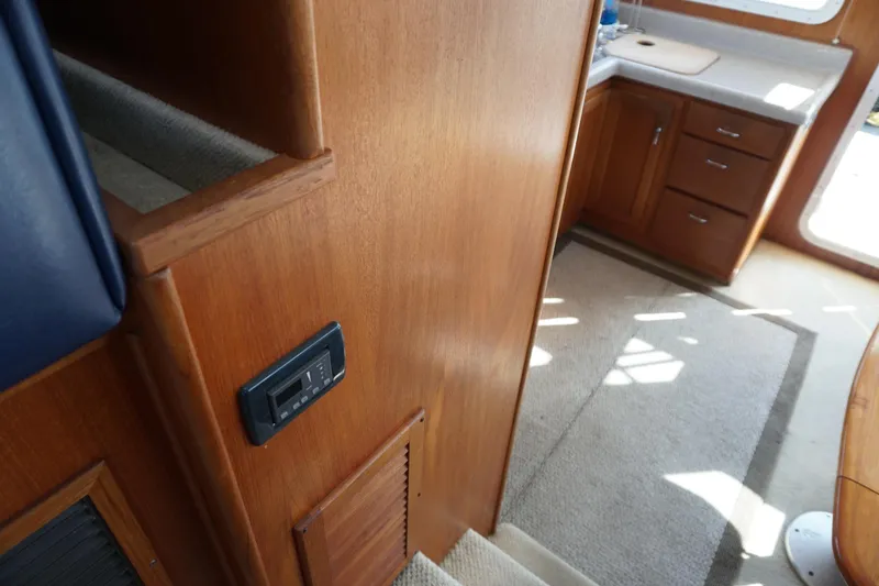 Slide: The Image of Interior of 2004 American Tug 34, featuring wooden cabinetry and carpeted flooring. - 26