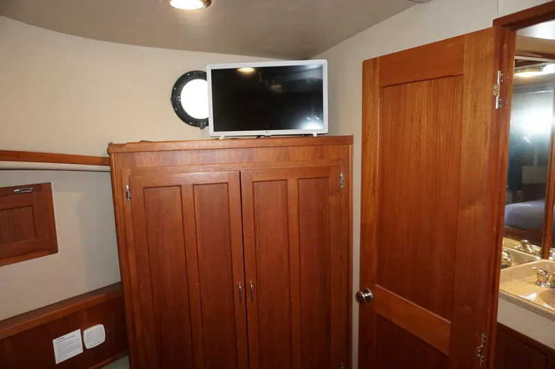 Slide: The Image of Interior of 2004 American Tug 34 with wooden cabinetry and mounted TV. - 29