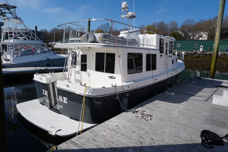 Slide: The Image of 2004 American Tug 34 docked at a marina, showcasing its sturdy design and spacious deck. - 3