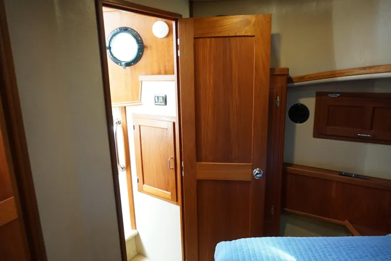 Slide: The Image of Interior of 2004 American Tug 34, featuring wooden cabinetry and a cozy cabin space. - 31