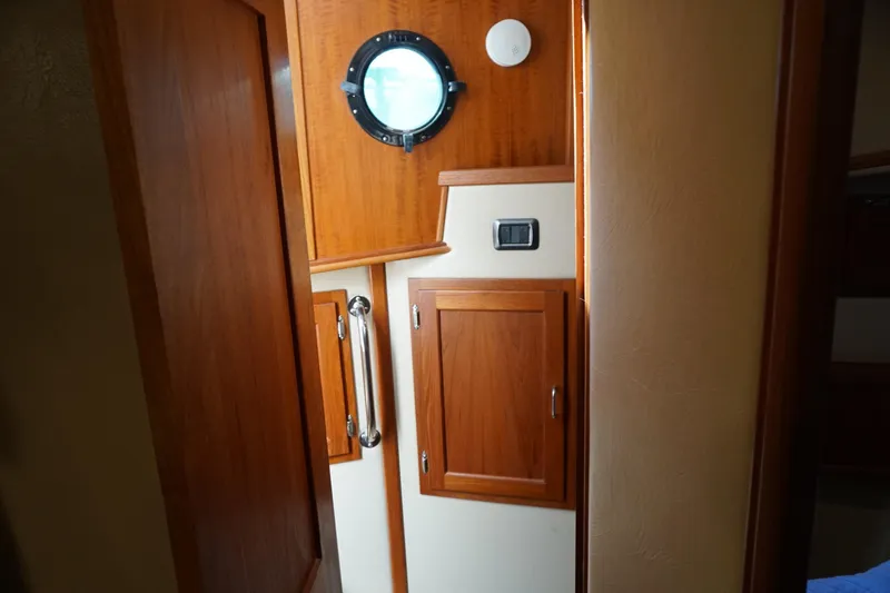 Slide: The Image of Interior of 2004 American Tug 34, featuring wooden cabinetry and a porthole window. - 37