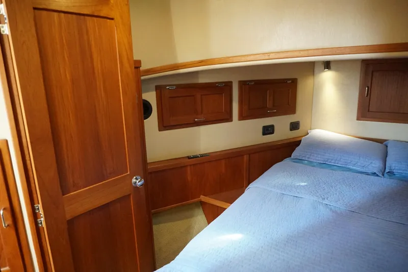 Slide: The Image of Cozy cabin interior of 2004 American Tug 34 with wooden finishes and comfortable bedding. - 38