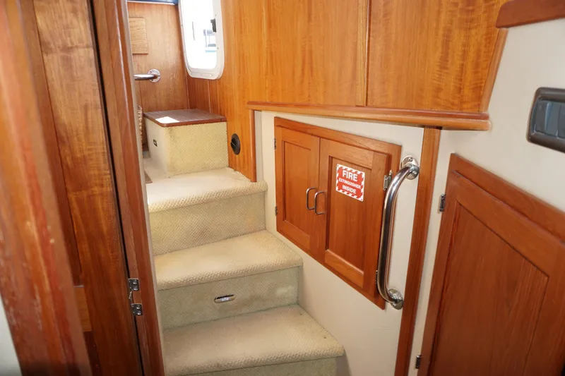 Slide: The Image of Interior stairs of 2004 American Tug 34 with wooden paneling and fire extinguisher cabinet. - 39