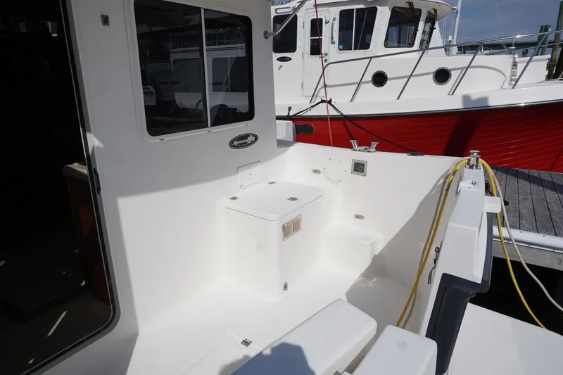 Slide: The Image of 2004 American Tug 34 boat deck with seating and docked alongside another vessel. - 47