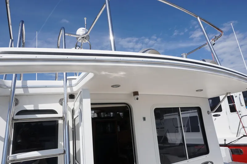 Slide: The Image of 2004 American Tug 34 boat exterior with ladder and railing under clear sky. - 48