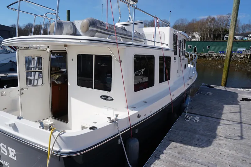 Slide: The Image of 2004 American Tug 34 docked, showcasing exterior design and spacious deck area. - 50