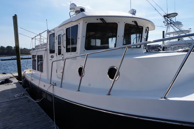 Slide: The Image of 2004 American Tug 34 docked at a marina, showcasing its sturdy design and sleek lines. - 53
