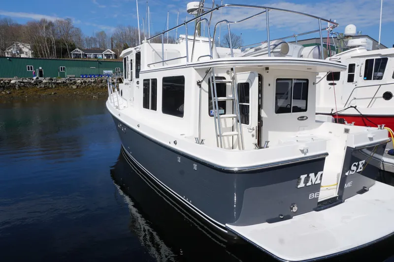 Slide: The Image of 2004 American Tug 34 docked in a marina, featuring a sleek design and spacious deck. - 54