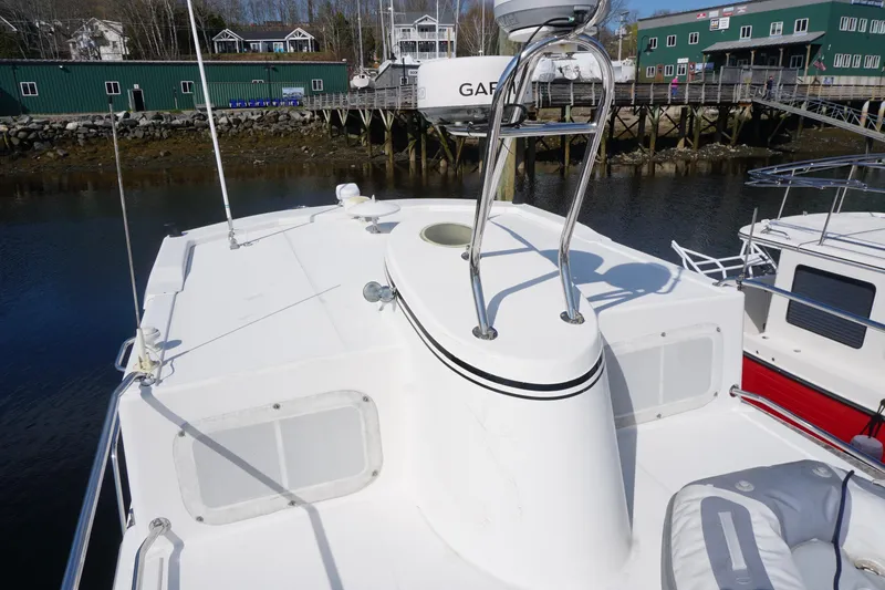 Slide: The Image of 2004 American Tug 34 boat deck with radar equipment, docked near waterfront buildings. - 55