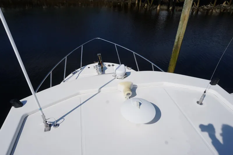Slide: The Image of Bow view of 2004 American Tug 34 on calm water, showcasing deck details. - 57