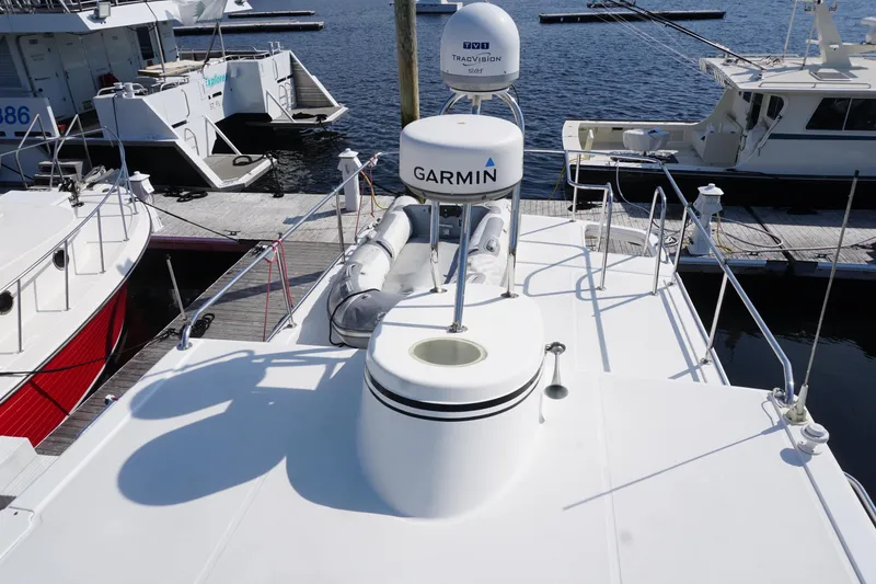 Slide: The Image of American Tug 34 (2004) boat docked, featuring Garmin and TracVision equipment on deck. - 59