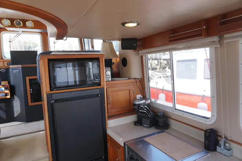 Slide: The Image of Interior of a 2004 American Tug 34, featuring a compact kitchen with appliances. - 8