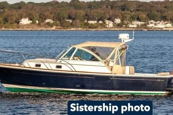 The Image of 2007 Hunt Yachts Surfhunter 29 cruising on a serene lake with forested shoreline. - 0