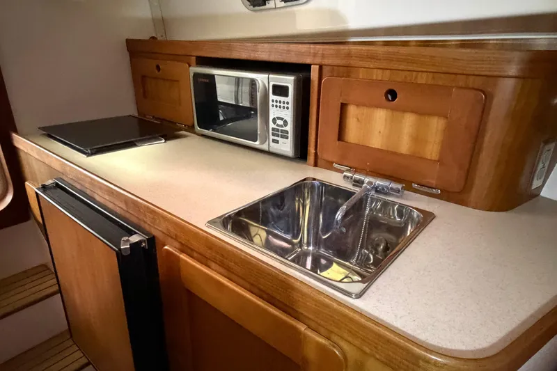 Slide: The Image of 2007 Hunt Yachts Surfhunter 29 galley with sink, microwave, and compact fridge. - 12