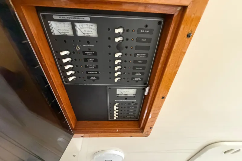 Slide: The Image of Electrical panel of 2007 Hunt Yachts Surfhunter 29 with wooden frame and labeled switches. - 8