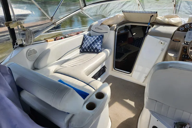 Slide: The Image of Interior of a 2002 Bayliner 2655 Ciera Sunbridge boat with white seating and blue pillow. - 4
