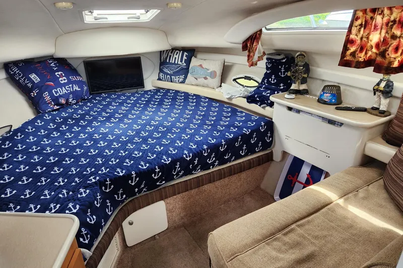 Slide: The Image of Interior of 2002 Bayliner 2655 Ciera Sunbridge with nautical-themed bedding and decor. - 7