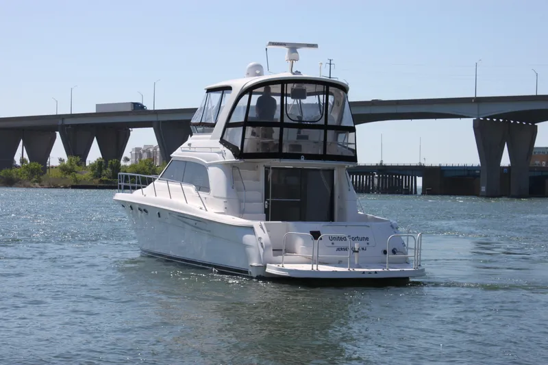 Slide: The Image of 2001 Sea Ray 480 Sedan Bridge yacht cruising near a bridge on a sunny day. - 10