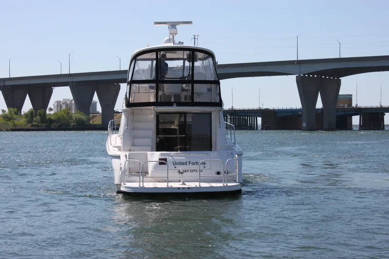Slide: The Image of 2001 Sea Ray 480 Sedan Bridge yacht cruising under a bridge on a sunny day. - 11