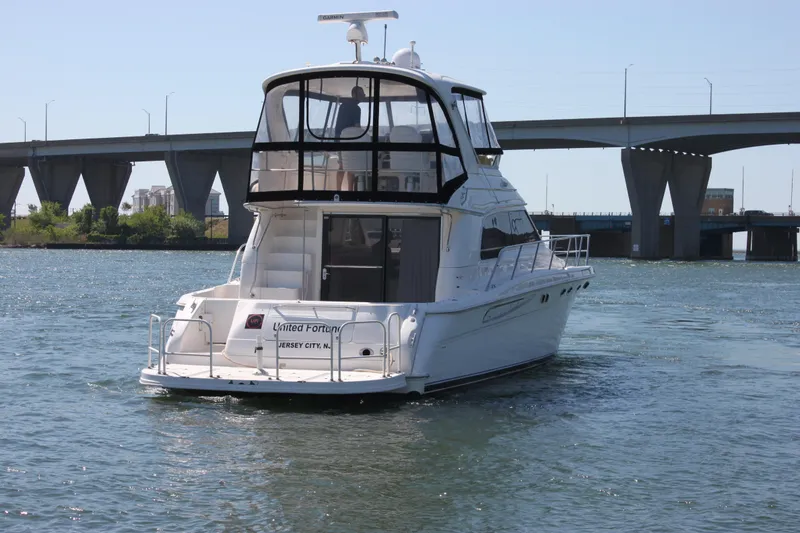 Slide: The Image of 2001 Sea Ray 480 Sedan Bridge yacht cruising near a bridge on a sunny day. - 12