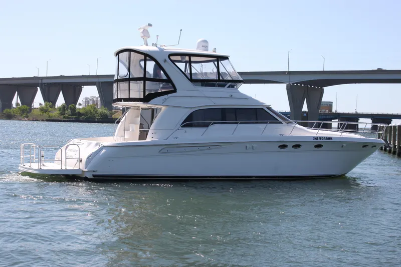 Slide: The Image of 2001 Sea Ray 480 Sedan Bridge yacht cruising near a bridge on a sunny day. - 14