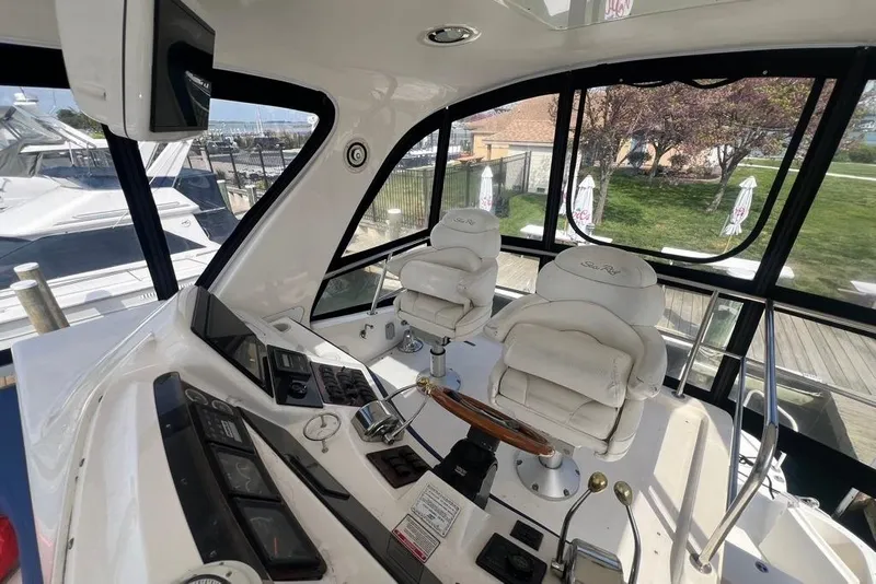 Slide: The Image of 2001 Sea Ray 480 Sedan Bridge cockpit with dual captain chairs and control panel. - 18