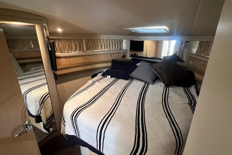 Slide: The Image of Luxurious bedroom interior of 2001 Sea Ray 480 Sedan Bridge yacht with striped bedding. - 19