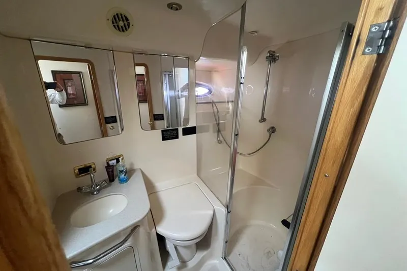 Slide: The Image of Bathroom interior of 2001 Sea Ray 480 Sedan Bridge yacht, featuring shower and vanity. - 22