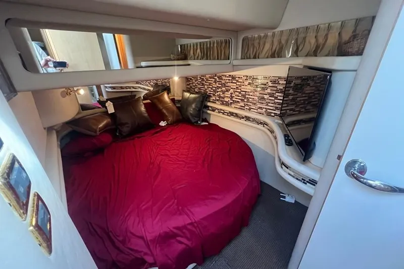 Slide: The Image of Luxurious cabin interior of 2001 Sea Ray 480 Sedan Bridge with red bedding and modern decor. - 23