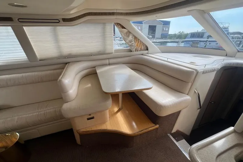 Slide: The Image of Interior of 2001 Sea Ray 480 Sedan Bridge yacht with plush seating and table. - 24