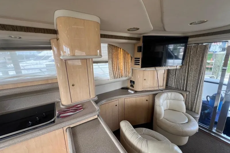 Slide: The Image of Interior of 2001 Sea Ray 480 Sedan Bridge yacht with modern furnishings and entertainment setup. - 27