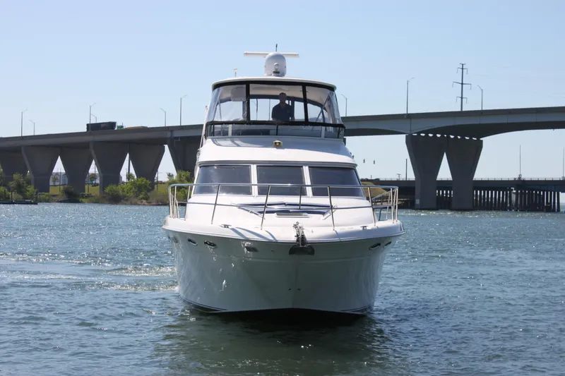Slide: The Image of 2001 Sea Ray 480 Sedan Bridge yacht cruising near a bridge on a sunny day. - 3