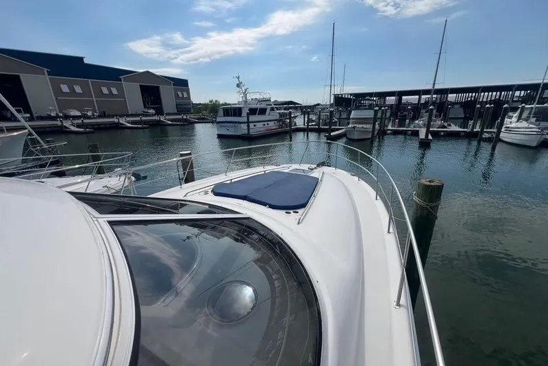 Slide: The Image of 2001 Sea Ray 480 Sedan Bridge yacht docked at a marina under a clear sky. - 30