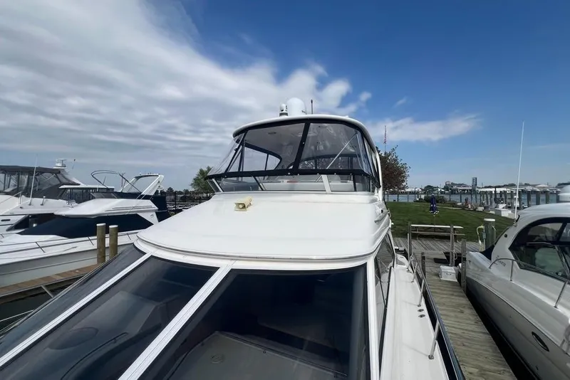 Slide: The Image of 2001 Sea Ray 480 Sedan Bridge yacht docked at marina under blue sky. - 32