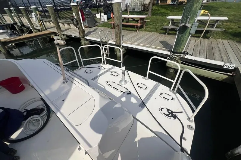 Slide: The Image of 2001 Sea Ray 480 Sedan Bridge yacht docked at marina, featuring spacious deck and railing. - 33
