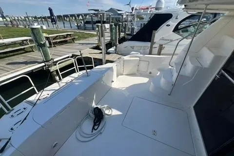 Slide: The Image of 2001 Sea Ray 480 Sedan Bridge yacht docked, featuring spacious deck and seating area. - 38
