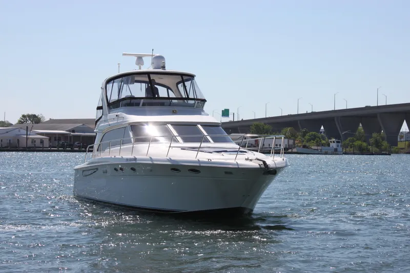 Slide: The Image of 2001 Sea Ray 480 Sedan Bridge yacht cruising on a sunny day near a bridge. - 4