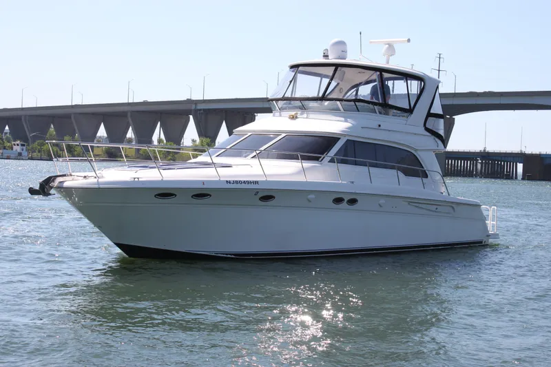 Slide: The Image of 2001 Sea Ray 480 Sedan Bridge yacht on water near a bridge. - 5