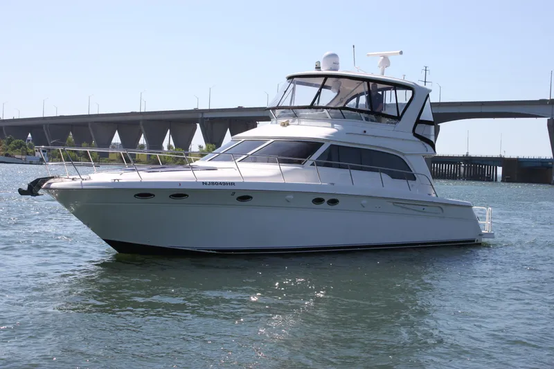 Slide: The Image of 2001 Sea Ray 480 Sedan Bridge yacht cruising near a bridge on a sunny day. - 6