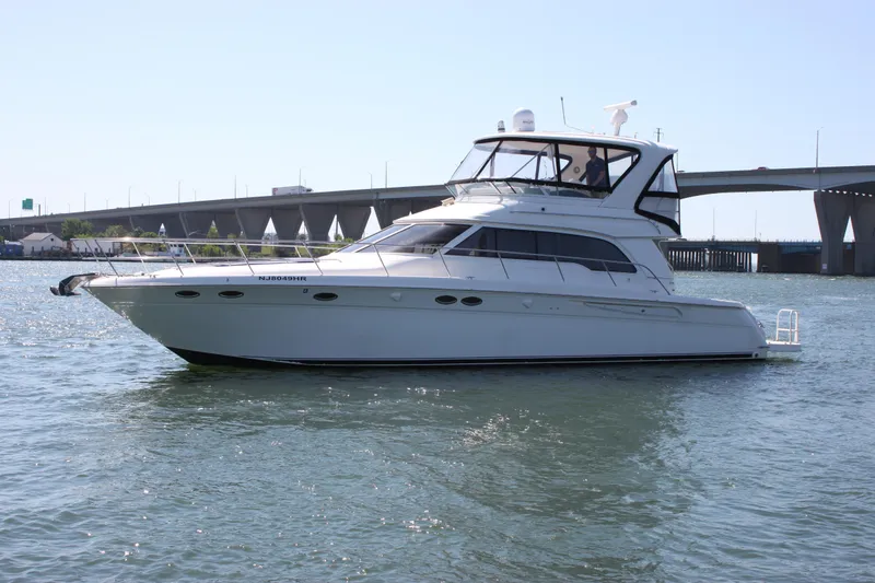 Slide: The Image of 2001 Sea Ray 480 Sedan Bridge yacht on water near a bridge. - 7
