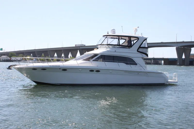 Slide: The Image of 2001 Sea Ray 480 Sedan Bridge yacht on water near a bridge. - 8